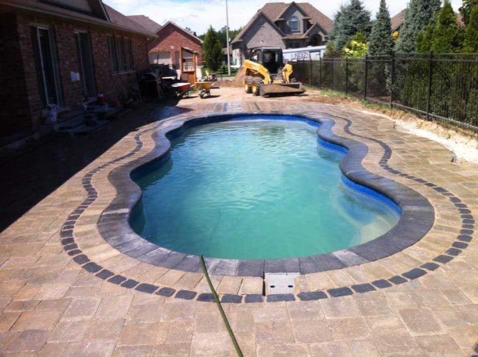 Freeform pool at night with stone waterfall and LED lighting