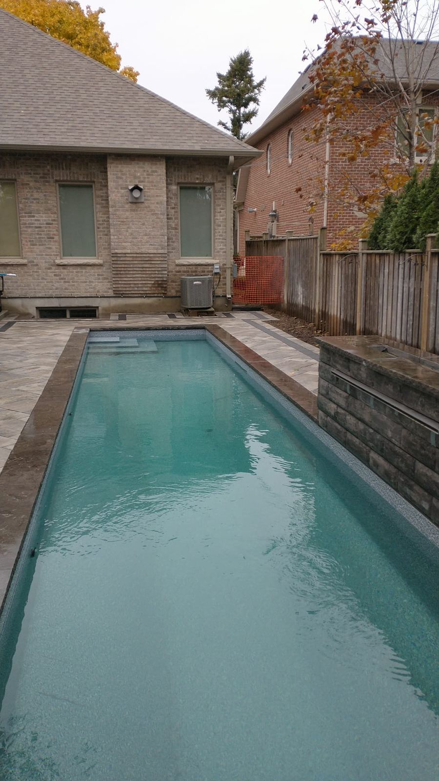 Rectangular pool with paver deck surrounded by fall foliage